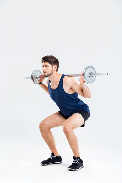 Beau jeune homme athlète faisant squats avec haltère — Photo