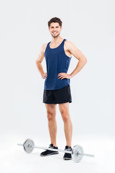 Smiling handsome young sportsman with barbell — Stock Photo, Image