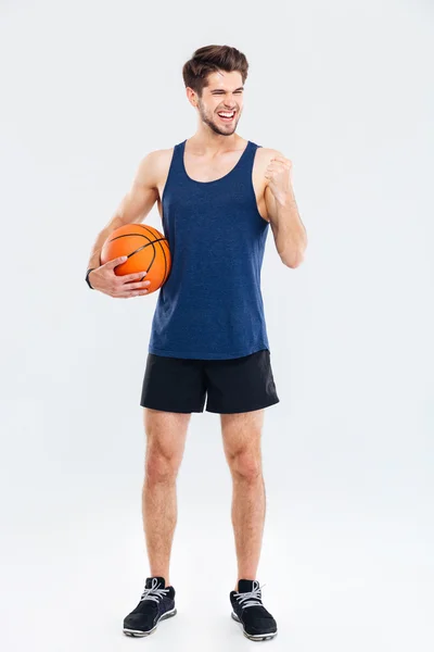 Homme riant avec ballon de basket isolé sur un fond gris — Photo