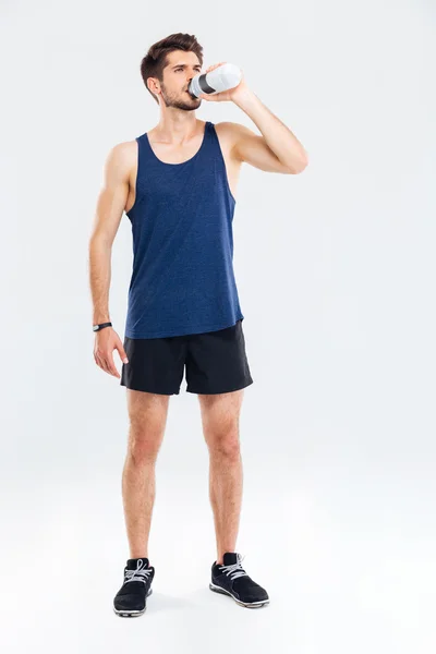 Full längd porträtt av en fitness man dricksvatten — Stockfoto
