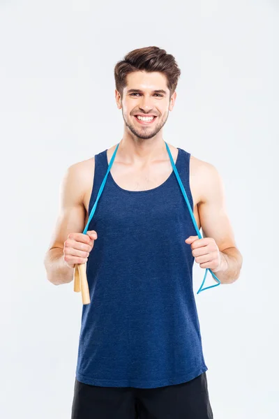 Sorrindo jovem atleta masculino de pé e segurando pulando corda — Fotografia de Stock