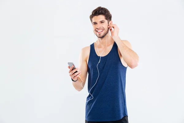 Glad ung man idrottsman lyssna på musik från mobiltelefonen — Stockfoto