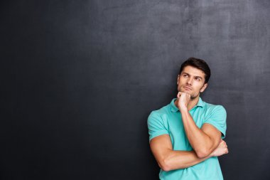 Ayakta ve düşünme düşünceli yakışıklı genç adam