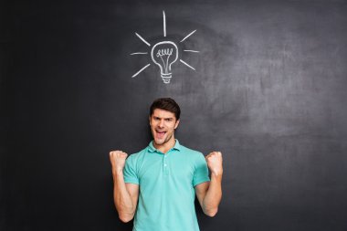 Başarı kutluyor ve bir fikir olan mutlu kendine güvenen genç adam