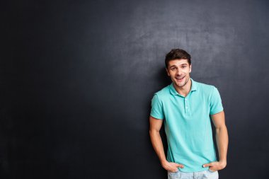 Yakışıklı genç adam siyah arka plan üzerinde kamera bakıyor