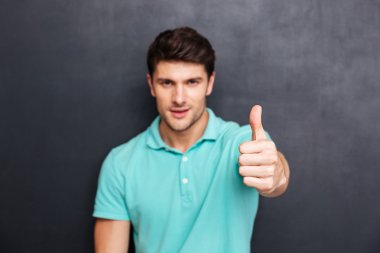 Yakışıklı delikanlı ile kameraya bakarak yukarı başparmak