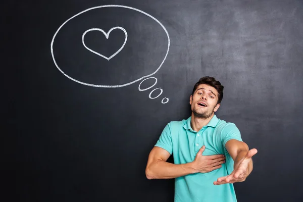 Man in love giving you his hand over chalkboard background — Stock Photo, Image