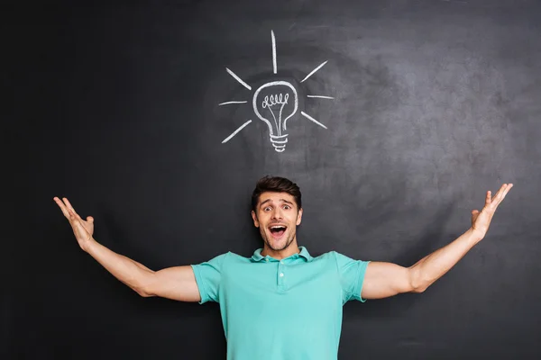 Smiling excited young man standing and having an idea — Stock Photo, Image