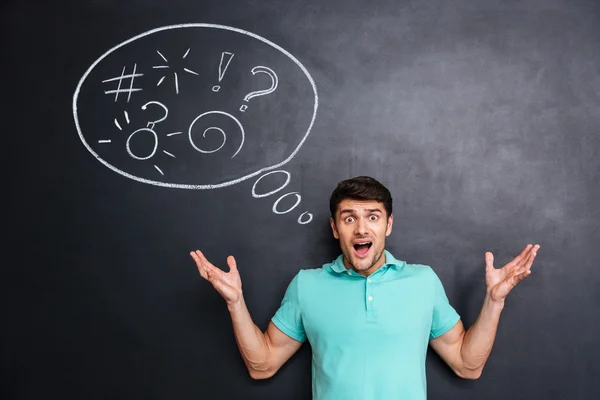 Angry astonished man shouting over blackboard background with speech bubble — Stock Photo, Image