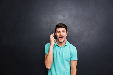 Yakışıklı genç adam parmağıyla izole siyah üzerinde çarpı işareti