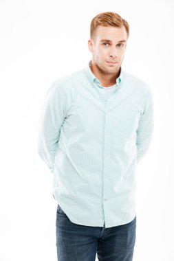 Elleri arkada duran ciddi çekici genç adam