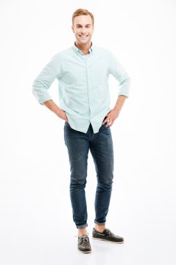 Neşeli yakışıklı genç adam ayakta ve gülümseyen tam uzunlukta