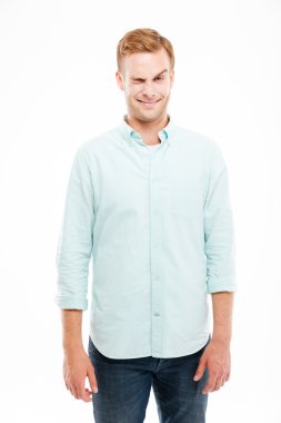 Gülümseyen oyuncu genç adam komik yüz yapma ve göz kırpma