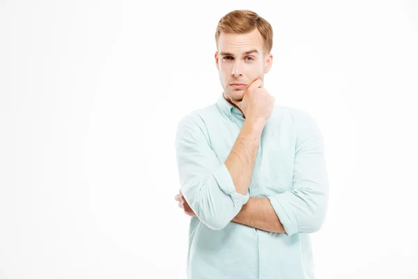 Pensive handsome young businessman stading with hands folded and thinking — Stock Photo, Image