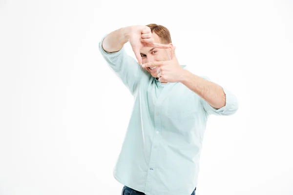 Smiling playful young man making frame by hands — Stock Photo, Image