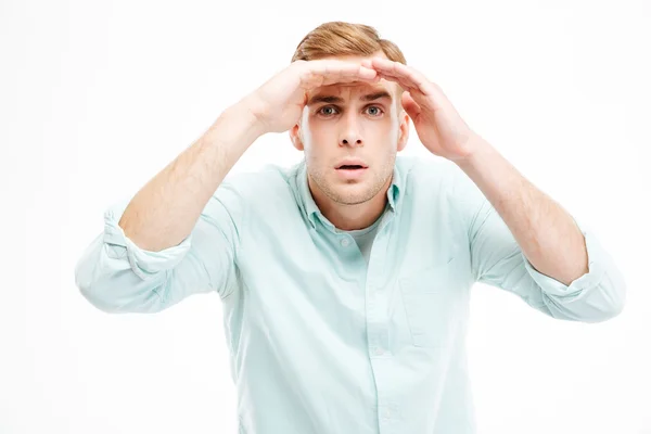 Joven y serio hombre de negocios enarbolando y mirando lejos — Foto de Stock