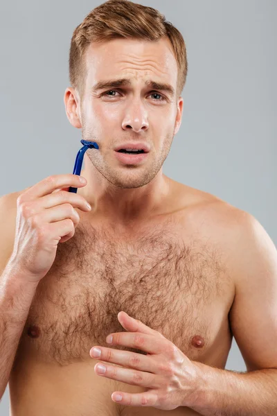 Man fears to shave over gray background — Stock Photo, Image