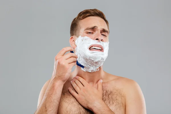 Man scares to shave over gray background — Stock Photo, Image