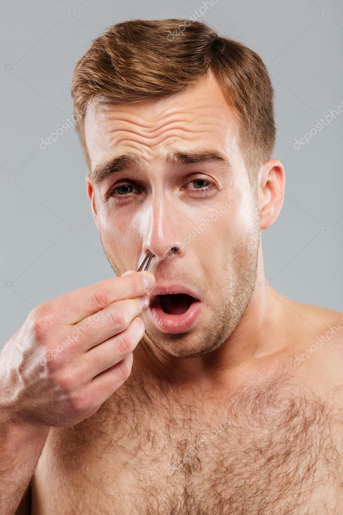 Close Up Portrait Of Man Removing Nose Hair With Tweezers Stock