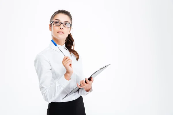 Pensive jovem empresária com clipboard segurando caneta — Fotografia de Stock