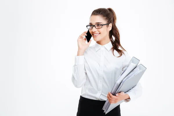 Jovem empresária feliz segurando pastas e falando no telefone celular — Fotografia de Stock