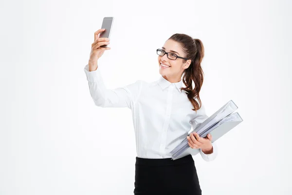 Feliz joven y atractiva empresaria en gafas tomando selfie usando smartphone —  Fotos de Stock