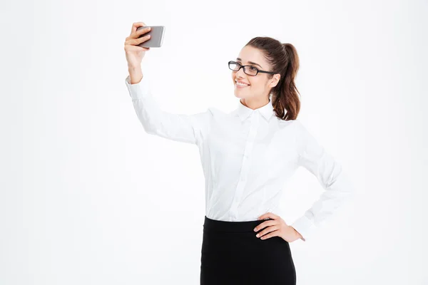 Lachende zakenvrouw in glazen maken selfie met behulp van mobiele telefoon — Stockfoto