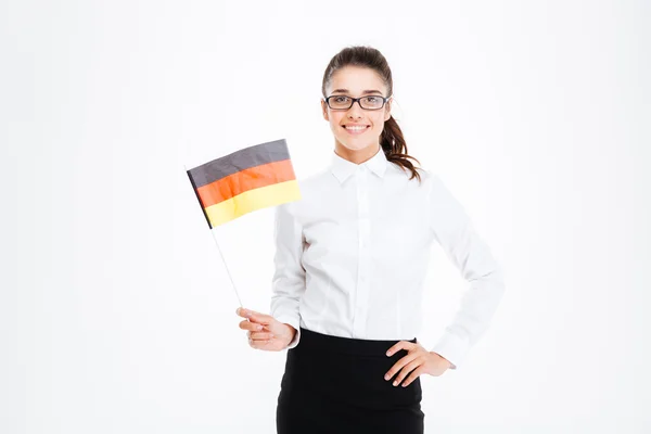 Smiling pretty young businesswoman standing and holding flag of Germany — Stock Photo, Image