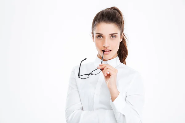 Nachdenkliche junge Geschäftsfrau steht und hält Brille — Stockfoto