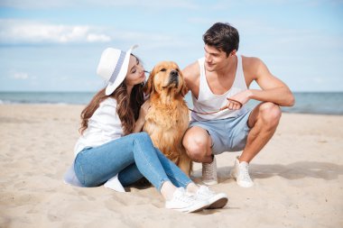 Köpekle oynamayı aşk oturuşta genç şık çift
