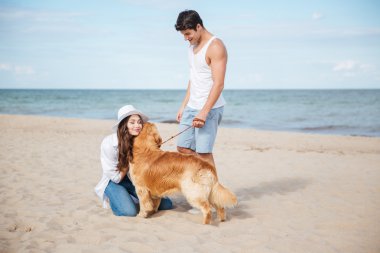 Köpek ile deniz kıyısında yürüyüş romantik genç Çift