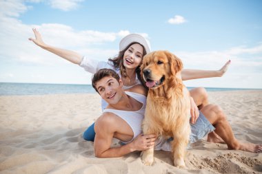 Sevgi dolu çift ile onların köpek deniz kenarında oynarken