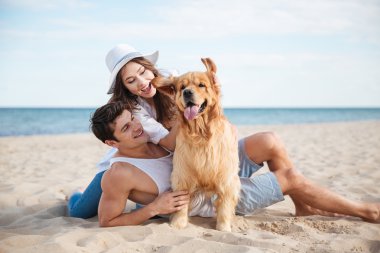 Genç çift ile onların köpek deniz kenarında oynarken