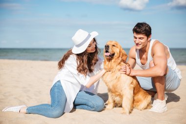 Köpekle oynamayı aşk oturuşta genç şık çift