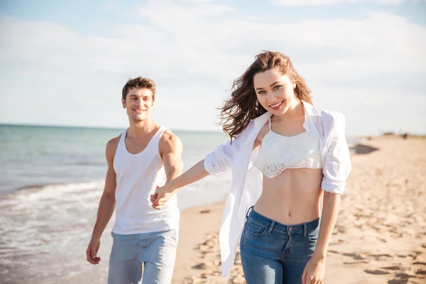 Casal sorrindo e andando na praia — Fotografia de Stock