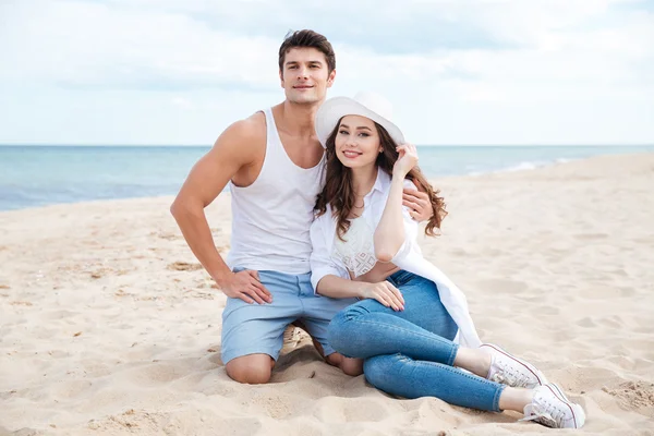 Lindo casal sentado na praia — Fotografia de Stock