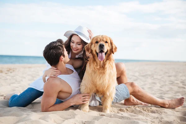 Par leker med sin hund vid havet — Stockfoto