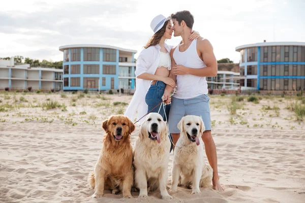 Vackra par kyssas på havsstranden med hund — Stockfoto
