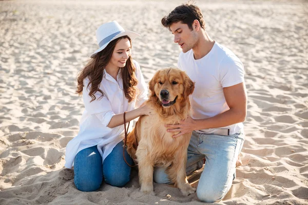 Casal passar tempo na praia com seu cão — Fotografia de Stock