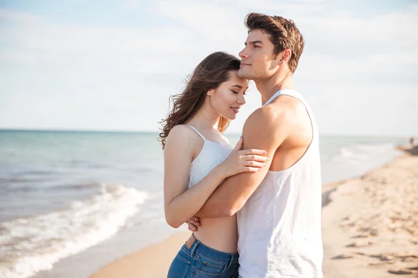 Hermosa pareja abrazándose en la playa — Foto de Stock