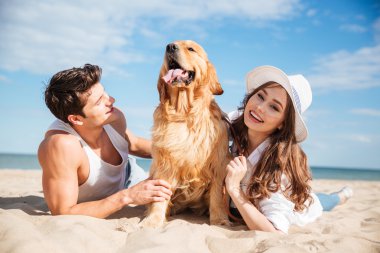 Genç çift sahilde köpekle yalan aşık