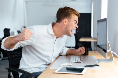 Bağırarak ve bilgisayar Office ile çalışan saldırgan öfkeli işadamı