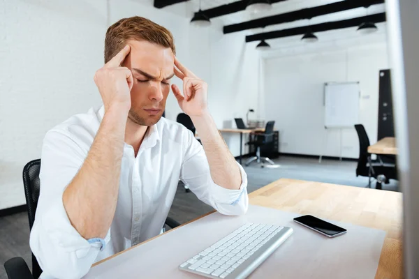 Joven empresario estresado con dolor de cabeza en el cargo —  Fotos de Stock