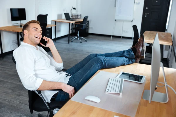 Podnikatel, sedí a mluví na mobil v úřadu — Stock fotografie