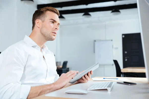 Empresario que usa tableta y computadora en la oficina —  Fotos de Stock