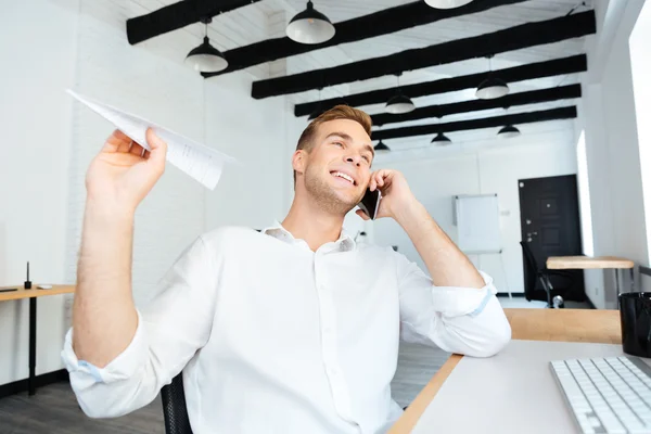 Glada affärsman talar i mobiltelefon och kasta papper plan — Stockfoto