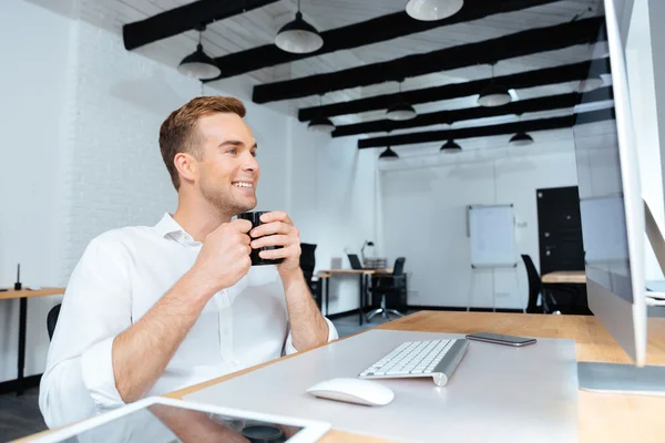 Boldog üzletember ül, és kávét iszik a munkahelyen — Stock Fotó