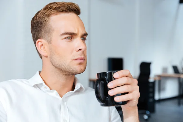 Hombre de negocios serio bebiendo café en offiice —  Fotos de Stock