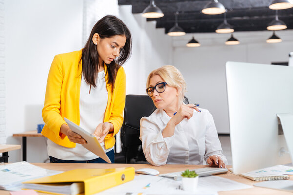 Две деловые женщины, работающие вместе
