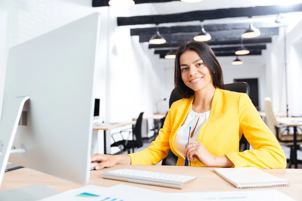 Retrato de uma empresária sorridente usando laptop no escritório — Fotografia de Stock